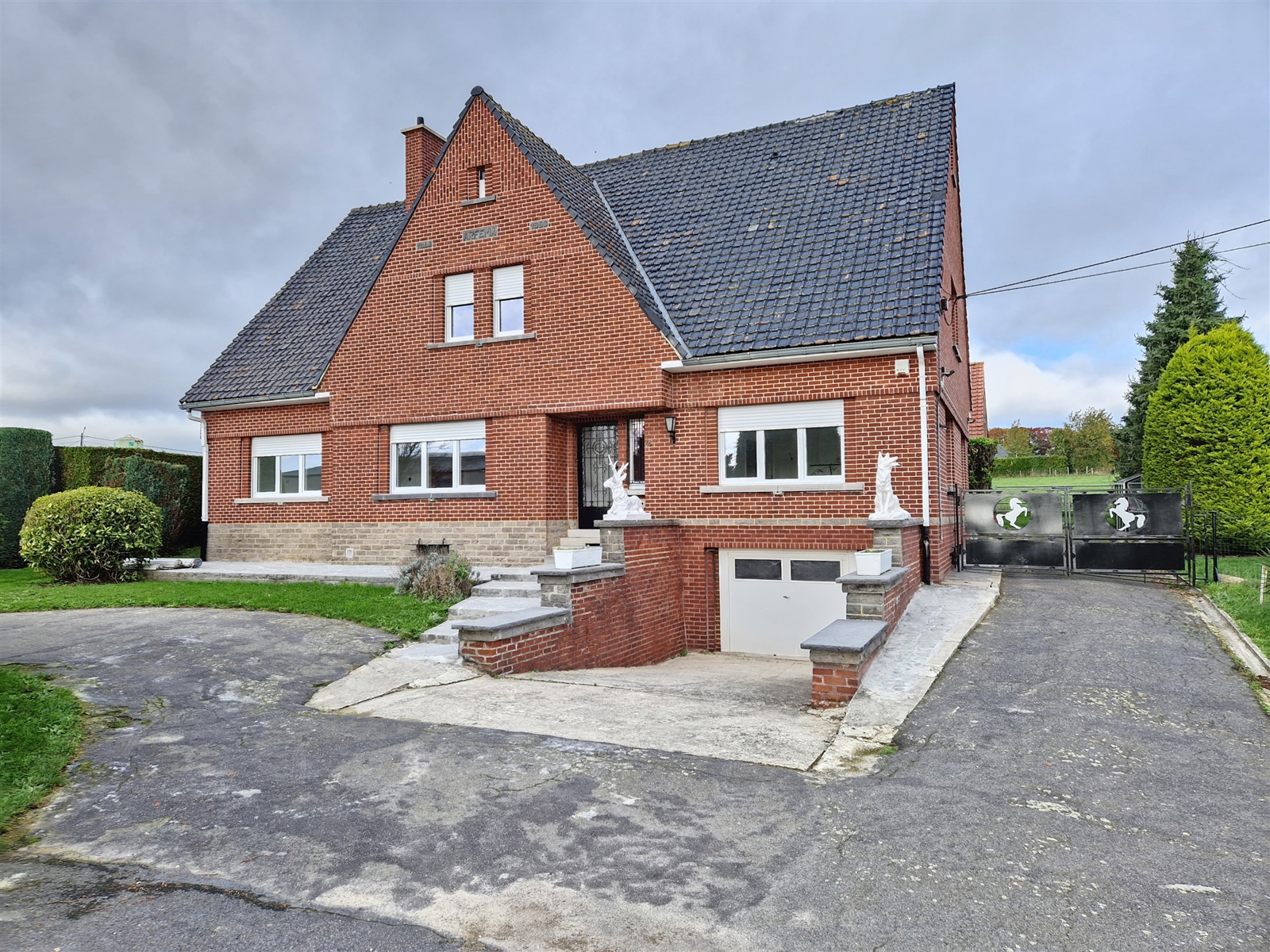 Spacieuse villa 4 façades de plain-pied avec terrasse et jardin arboré, située dans la région des collines, tout en étant proche des facilités. Elle comprend un hall d'entrée, grand séjour lumineux, cuisine équipée, toilette, salle de bain, 3 chambres - Garage, parking extérieur aisé. Chauffage central mazout. A découvrir sans tarder! 70€ de provision pour l'entretien du jardin. La location ne concerne que le rez-de-chaussée et la cave, le grenier ne fait pas partie de la location.