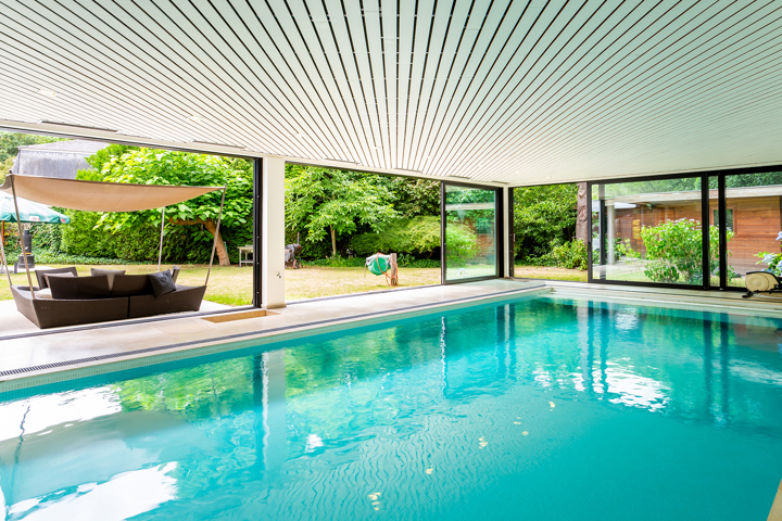 Topgelegen architectenwoning met ruim tuin en binnenzwembad.